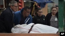 In this Jan. 11, 2018 photo, forensic workers remove the body of a man found fatally shot in San Juan, Puerto Rico. As the Island struggles to recover from Hurricane Maria, it is facing one of the biggest spikes in violent crime in nearly a decade.