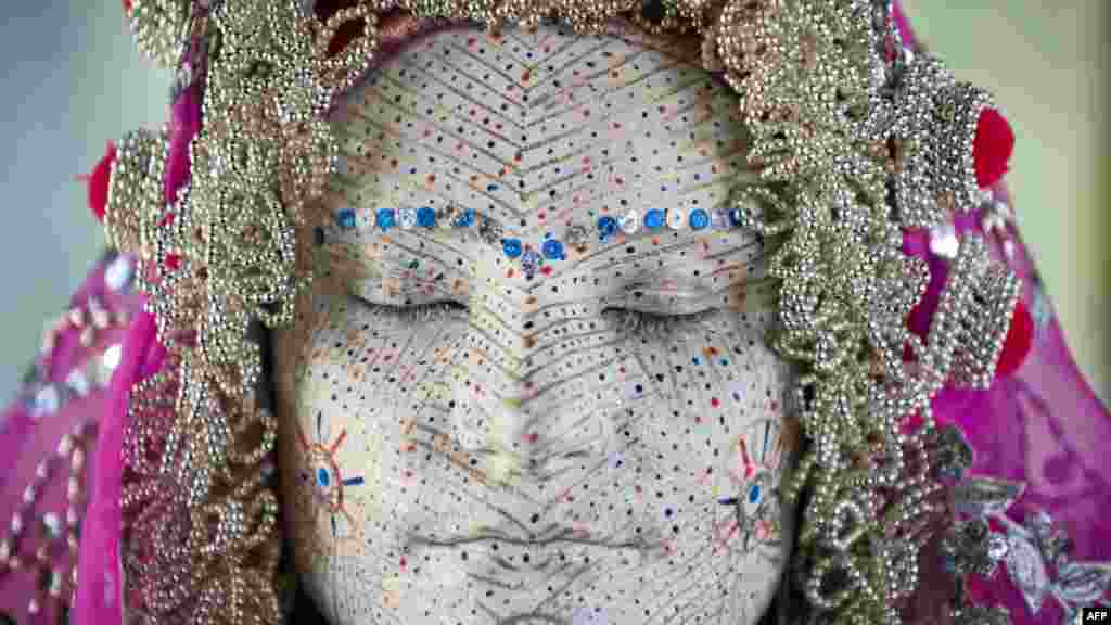 Une femme Kosovar bosniaque, Arleta Sahiti, pose après que son visage a été peint par une femme lors d'une présentation de la cérémonie de mariage traditionnel de femmes bosniaques de la région de Zhupa au musée d'ethnologie à Pristina, 2 Juillet, 201.