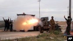 Imam Ali Brigades, members of of an Iraqi Shiite group, launch rockets against Islamic State extremist positions during clashes in Tikrit, 130 kilometers north of Baghdad, Iraq, March 24, 2015.