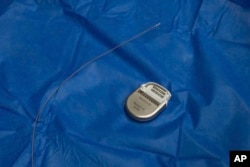 A sample pacemaker-like device, used for deep brain stimulation therapy, and its electrodes which are implanted into a specific site in the brain are displayed at Mount Sinai West in New York on Dec. 20, 2023. (AP Photo/Mary Conlon)