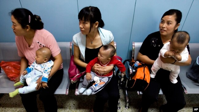 在为农民工提供母婴检查的北京朝阳区十八里店乡医院，中国妇女抱着孩子等着看医生。（2007年9月5日资料照）