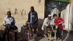 Migrant workers repairing clothes in the street in Benghazi, Libya