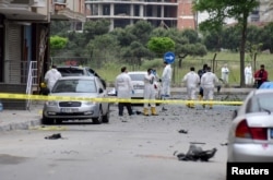 Police forensic experts examine a scene following a vehicle explosion near a military facility in Istanbul, Turkey, May 12, 2016.