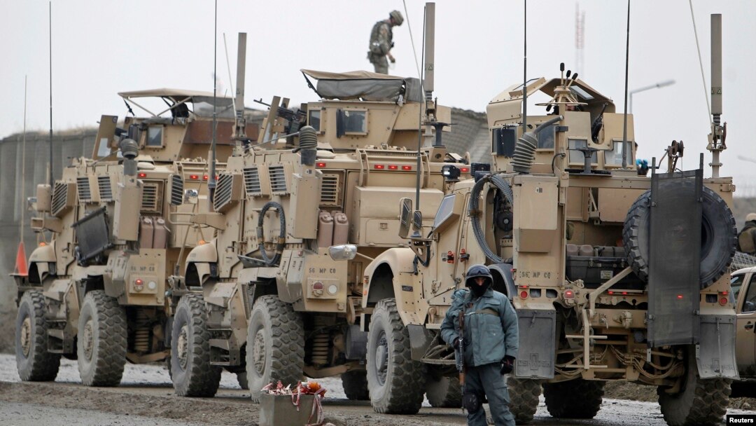 Seorang polisi Afghanistan berjaga dekat truk NATO dekat lokasi serangan bom bunuh diri di Kabul, 11 Desember 2013 (Foto: dok). Pembom bunuh diri Taliban menyerang truk-truk tangki NATO dekat perbatasan Pakistan, Rabu (18/12).