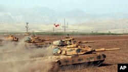 FILE - Turkish army tanks move during exercises in Silopi, near the Habur border gate with Iraq, southeastern Turkey, Sept. 25, 2017. (DHA-Depo Photos via AP)