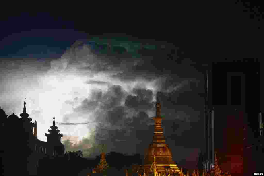 Petir terlihat di atas pagoda Sule dan bekas balai kota Rangoon, Burma (13/5).
