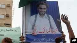 Pakistani activists of Baloch Rights Council holds a portrait of top Sunni militant leader Abdolmalek Rigi as they shout anti-Iran slogans at a protest in Karachi (File Photo)