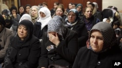 Women react inside the Kurdish cultural center in Paris, January 10, 2013. 