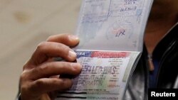 FILE - A Yemeni national who was denied entry into the U.S. shows a cancelled visa in his passport, at Washington Dulles International Airport, in Dulles, Virginia, Feb. 6, 2017.