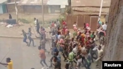 Demonstrators run along a street in Asella, Oromiya Province, Ethiopia Feb. 13, 2018, in this still image taken from a social media video. (TWITTER/@WAGUWAGU91) 