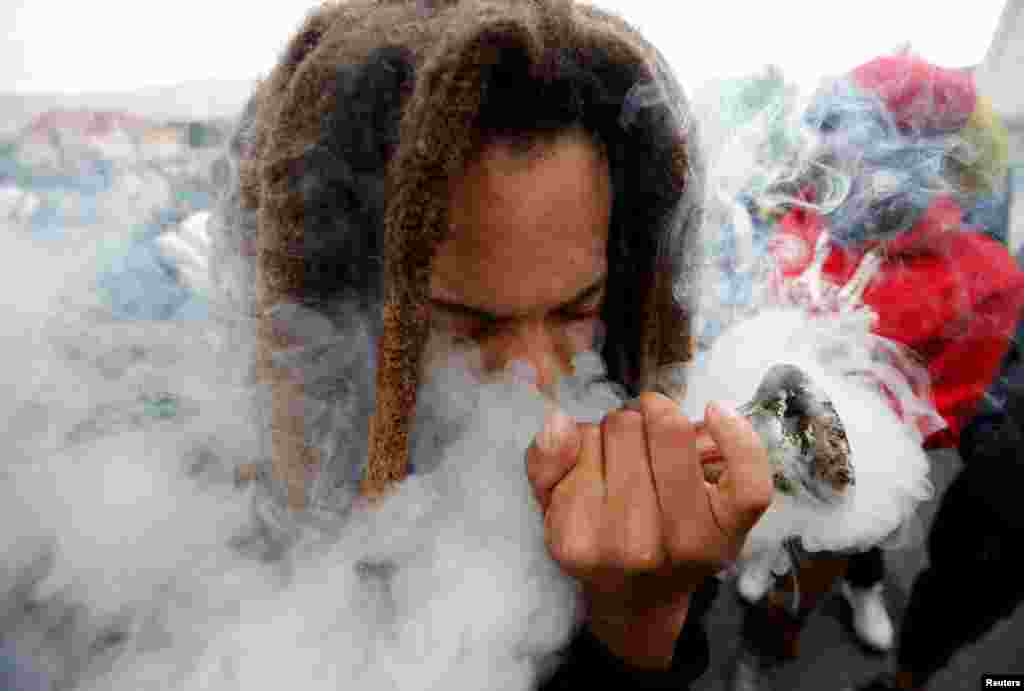 A man smokes marijuana, known locally as dagga, during a march calling for the legalization of cannabis in Cape Town, South Africa, May 6, 2017.