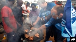 Rugby fans pour some beer on their braai meat , Soweto, South Africa, May 29, 2010 file photo.