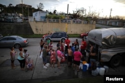 Local residents wait in line during a water distribution in Bayamon following damages caused by Hurricane Maria in Las Piedras, Puerto Rico, Oct. 1, 2017