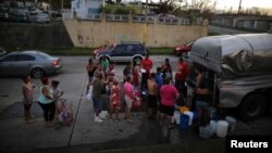 Local residents wait in line during a water distribution in Bayamon following damages caused by Hurricane Maria in Las Piedras, Puerto Rico, Oct. 1, 2017 