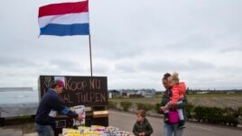 Frans van der Slot, left, puts tulips for sale on a stand outside his farm in Lisse, near Amsterdam, Netherlands, Thursday, March 19, 2020.