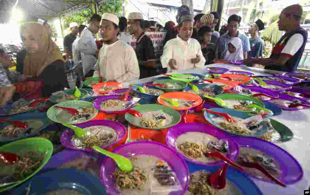 Warga mengambil makanan berbuka gratis yang disediakan Masjid Raya Al Mashun di Medan, Sumatra Utara, 7 Mei 2019. 