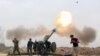 FILE - Iraqi security forces fire at Islamic State militants positions from villages south of the Islamic State group-held city of Mosul, Iraq, March 26, 2016.
