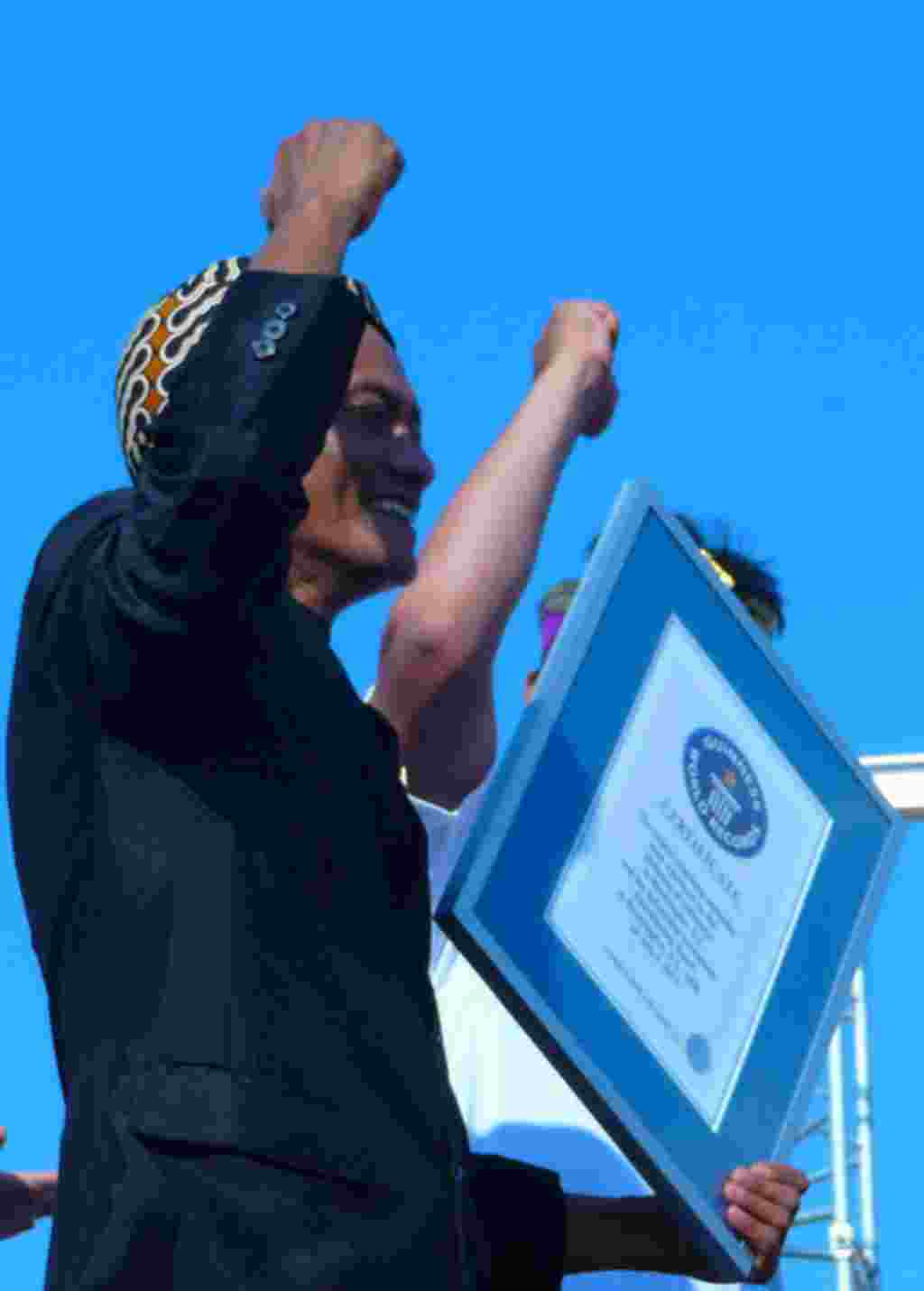 Mang Udjo menge palkan tangan ke udara setelah rekor Guiness Book of World Records untuk ansembel angklung terbesar resmi tercetak (foto: Ratnasari Dewi-VOA)