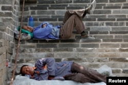 People rest after working on the reconstruction of the Jiankou section of the Great Wall, in Huairou District, north of Beijing, China, June 7, 2017.