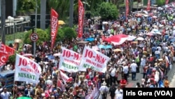 Ribuan massa memadati jalanan protokol dari Gedung MPR menuju Monas, Jakarta untuk menyambut Presiden Jokowi dan Wapres Jussuf Kalla yang baru saja dilantik, 20 Oktober 2014 (Foto: VOA/Iris Gera)
