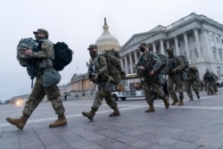National Guard soldiers walk out of the U.S. Capitol, Jan. 16, 2021, in Washington, as security is increased ahead of the inauguration.