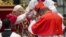 Newly elected Cardinal John Olorunfemi Onaiyekan of Nigeria, right, receives the red three-cornered biretta hat by Pope Benedict XVI during a consistory inside the St. Peter's Basilica at the Vatican, Nov. 24, 2012.