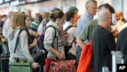 People wait in line at the security checkpoint at the Portland International Airport, July 3, 2012, in Portland, Oregon.