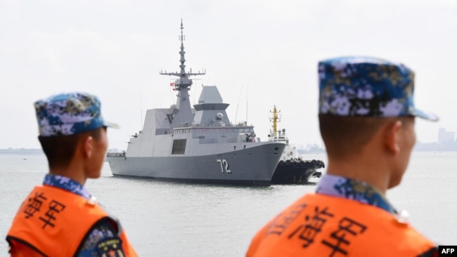 中国海军水手看着一艘新加坡舰船抵达位于广东省的军事基地（2018年10月21日）