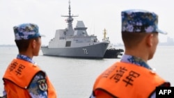 This photo taken on October 21, 2018 shows Chinese sailors watching as a Singapore navy ship arrives at a military port in Zhanjiang, in China's southern Guangdong province. 