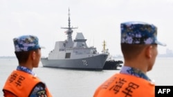 This photo taken on Oct. 21, 2018 shows Chinese sailors watching as a Singapore navy ship arrives at a military port in Zhanjiang, in Guangdong province. China and Southeast Asian states will hold their first joint maritime exercises this week, officials. 