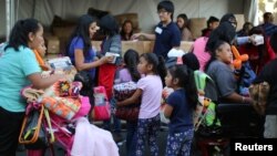 FILE - People receive free blankets as Thanksgiving meals are served in the Skid Row district of Los Angeles, California, Nov. 23, 2016. 