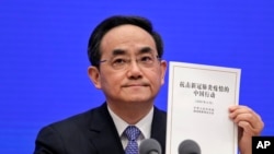 Xu Lin, Vice head of the Publicity Department of Communist Party, shows a copy of the white paper on fighting COVID-19 China during a press conference at the State Council Information Office in Beijing, June 7, 2020.