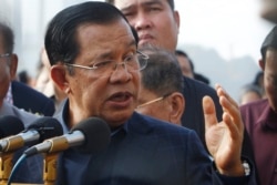 FILE - Cambodia's Prime Minister Hun Sen delivers a speech to passengers after they disembarked from the MS Westerdam, owned by Holland America Line, at the port of Sihanoukville, Cambodia, Friday, Feb. 14, 2020.