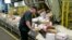 A U.S. postal worker arranges packages on a conveyor belt at the main post office in Omaha, Nebraska, Dec. 14, 2017.
