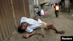 A man sleeps on the streets after drinking distilled traditional alcoholic liquor, locally known as "chang'aa", in the suburbs of Nairobi May 9, 2014