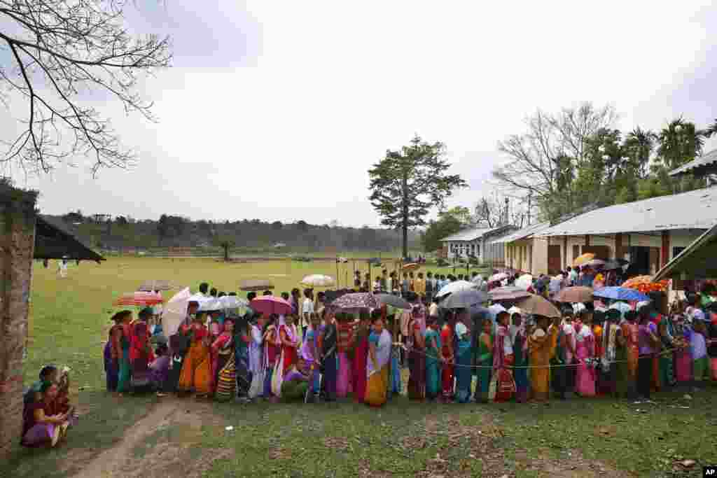 People stand in queue to cast their votes during the first phase of elections in Mandai, in the northeastern state of Tripura. India started the world&#39;s largest election Monday, with voters in the remote northeast making their way past lush rice paddies and over rickety bamboo bridges to reach the polls.