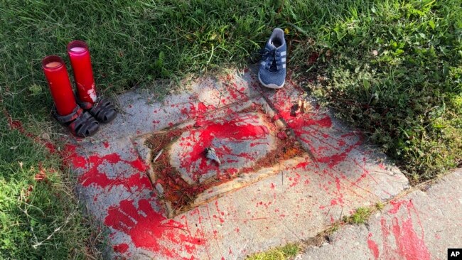 Red painted handprints cover the empty spot at a park in Albuquerque, New Mexico, on Thursday, July 1, 2021, where a historical marker for the Indigenous children who died while attending a boarding school nearby was removed.