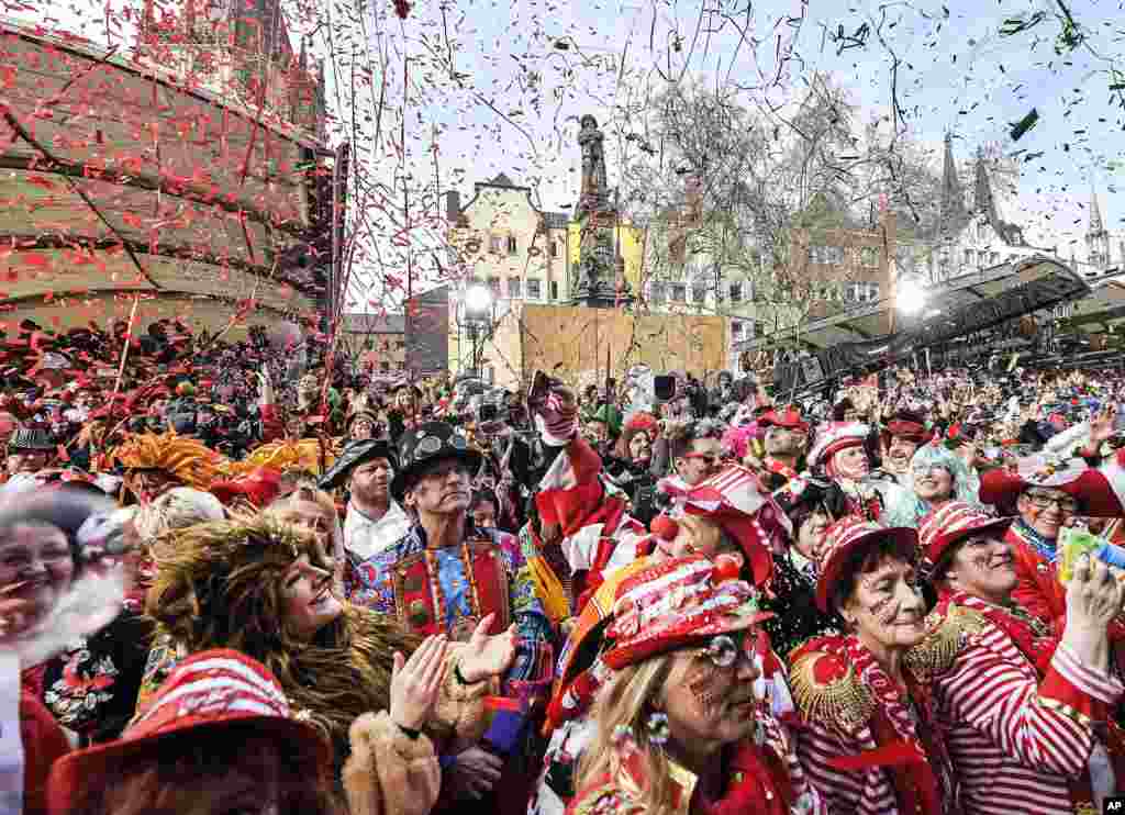 Thousands of people dressed in carnival costumes celebrate the start of the street carnival in Cologne, Germany.