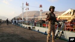 Yemeni militiamen stand guard at the port in Mukalla, Nov. 29, 2018.