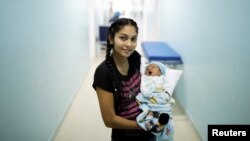 FILE - Jasmilfer, 23, a Venezuelan from Monagas state, holds her five-day-old baby Arjunea at a maternity hospital in Boa Vista, Roraima state, Brazil, Aug. 21, 2018. 