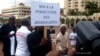 FILE - A Cameroonian journalist holds a sign raeding "No to the persecution of journalists" during a free speech rally in Yaounde, Cameroon, May 3, 2010. 