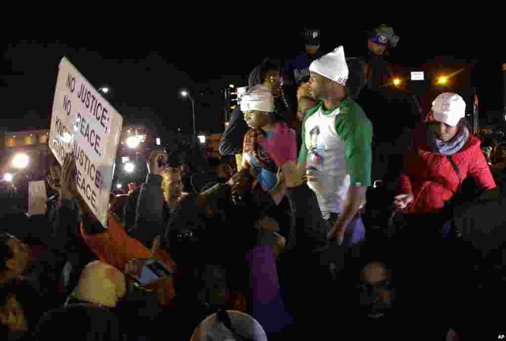 Lesley McSpadden, the mother of Michael Brown, left standing on the top of a car, reacts as she listens to the announcement of the grand jury decision, Nov. 24, 2014, in Ferguson, Missouri. 