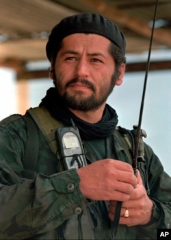 FILE - Henry Castellanos, also known as Romana, a senior commander of the Revolutionary Armed Forces of Colombia, talks on the radio in El Calvario, Colombia, March 27, 1998.