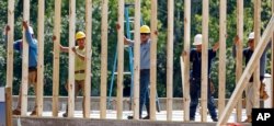 FILE - Construction workers set up a frame for what will eventually become a jewelry store, in Jackson, Miss., Aug. 21, 2017.