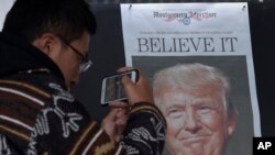 Zheng Gao of Shanghi, China, photographs the front pages of newspapers on display outside the Newseum in Washington, Nov., 9, 2016, the day after Donald Trump won the presidency.