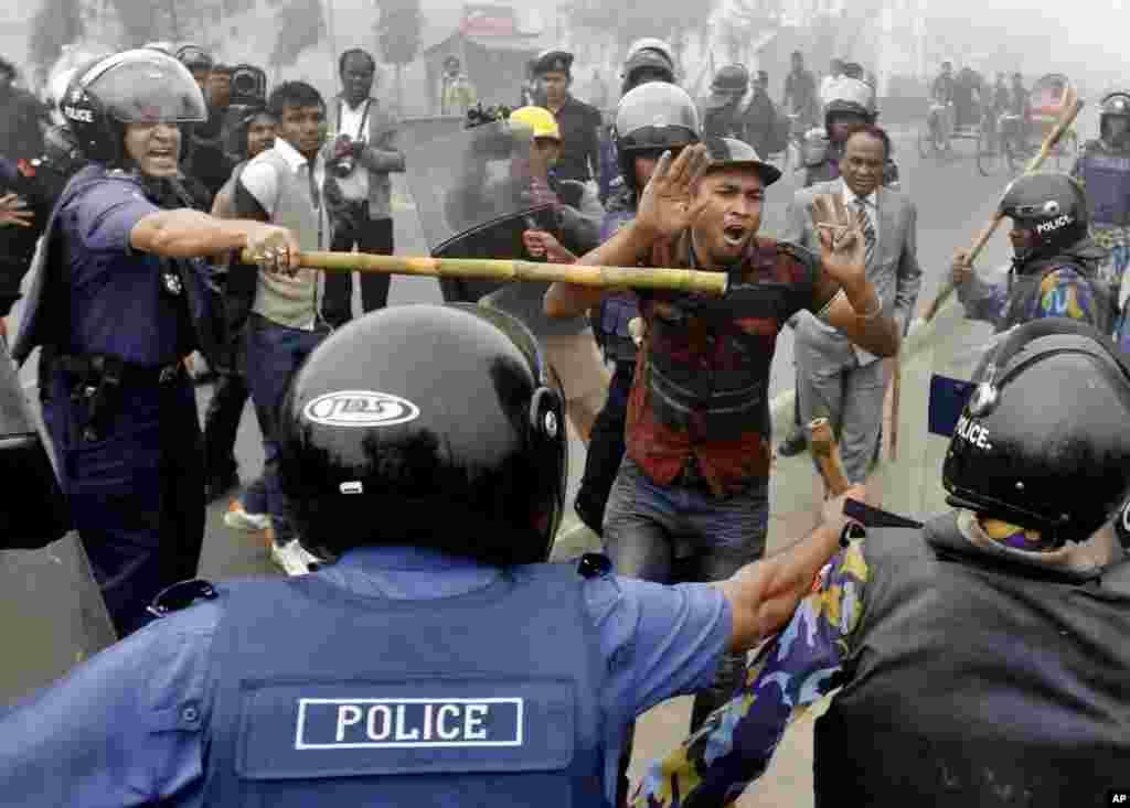 Police officials wield bamboo sticks to stop main opposition Bangladesh Nationalist Party activist during a protest in Kachpur, on the outskirts of Dhaka, December 9, 2012.