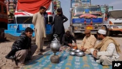 Des conducteurs des camions en Afghanistan attendent l'ouverture de la frontière pakistanaise à l'extérieur de Peshawar, au Pakistan, le 14 mars 2017.