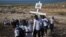 Relatives of those who died in the 2010 earthquake walk to place a cross on a hilltop to remember those who died in the devastating earthquake atTitanyen, a mass burial site north of Port-au-Prince, Haiti, Jan. 12, 2013.