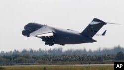 A C-17 cargo plane loaded with humanitarian commodities takes off from Homestead Air Reserve Base in route to Venezuela, Saturday, Feb. 16, 2019, in Homestead, Fla. 