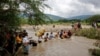 Les migrants utilisent une corde pour traverser le fleuve Tachira, la frontière naturelle entre la Colombie et le Venezuela, car la frontière officielle reste fermée en raison de la pandémie COVID-19 à Cucuta, Colombie, 19 novembre 2020. 